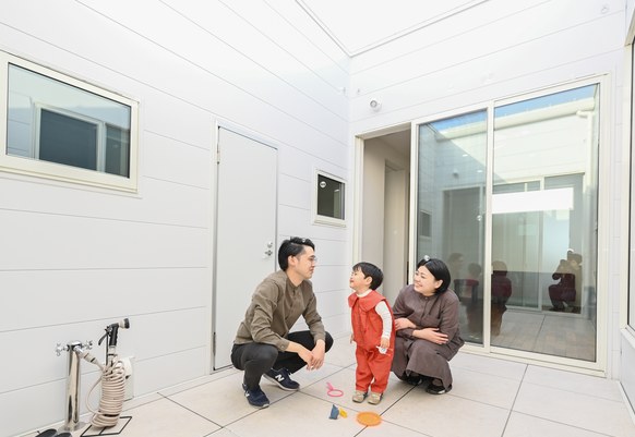 中庭で遊ぶ子どもと家族