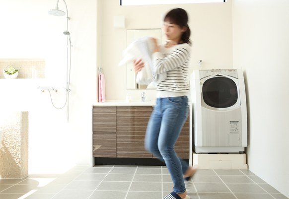 洗濯物を運ぶ女性とランドリースペース