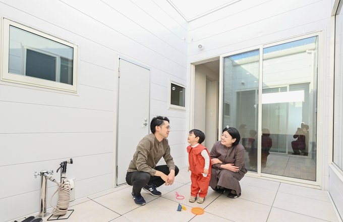 中庭で遊ぶ子どもと家族