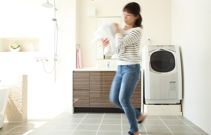 洗濯物を運ぶ女性とランドリースペース